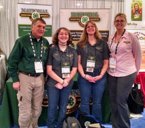 Members of the National 4-H Shooting Sports Committee, Dr. Mark Tassin of Louisiana State University (L) and Nicole Pokorney of the University of Minnesota (R) greet New York State 4-H Shooting Sports Teen Ambassador Logan Kimble-Lee (CL) and New York State 4-H Shooting Sports Instructor Colleen Kimble (CR) at the National booth at the 2016 SHOT Show in Las Vegas, NV.